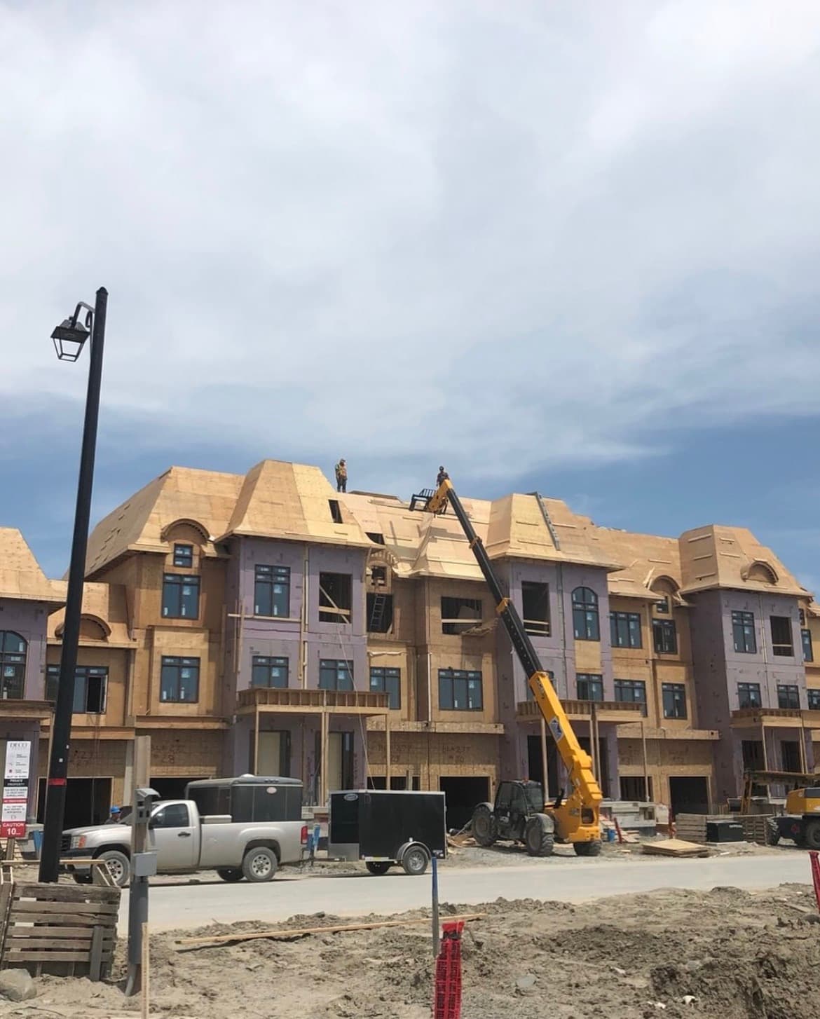 Crew framing a multi-unit build with a crane on site